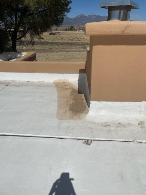 Close-up of damaged flat roof surface showing UV damage and staining